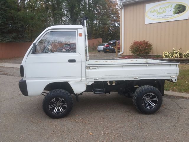 A lifted Japanese Kei Truck of a white kei truck.
