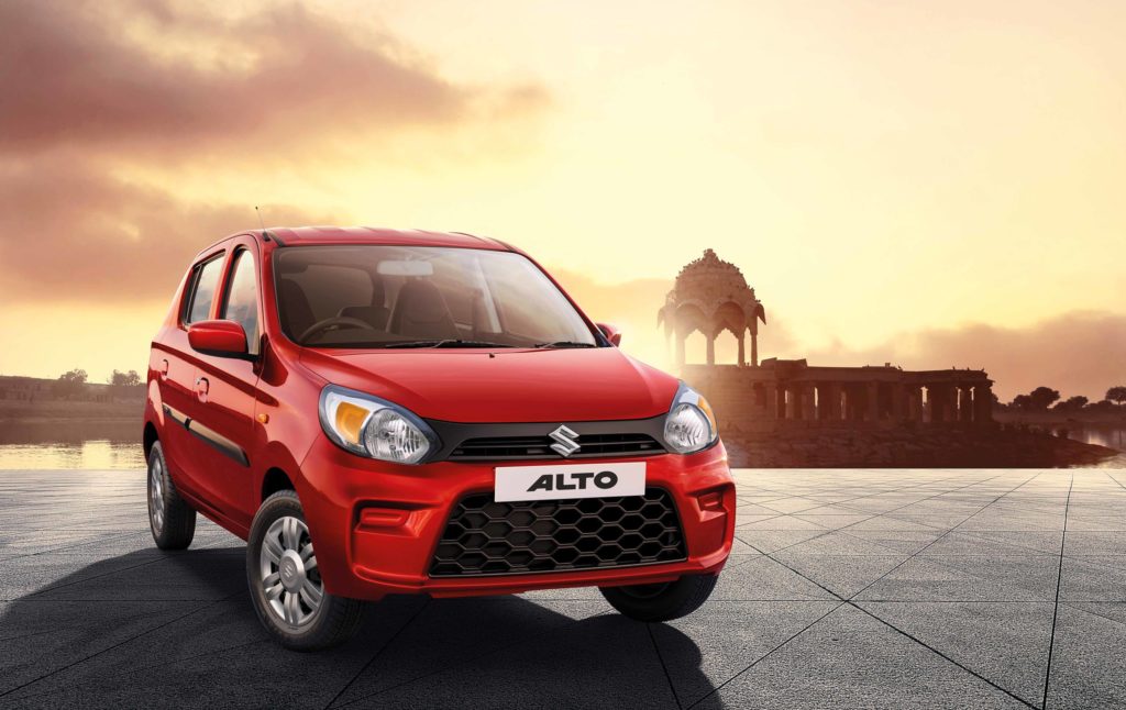 Suzuki Alto shown from the front against a sunset.